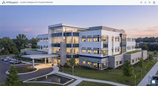 A modern medical facility building at dawn with large windows and a bright, airy feel.